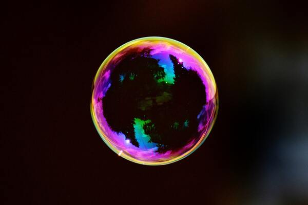Threshold Frequency of a Bubble is Positively Correlated to the Density of the Surrounding Fluid
